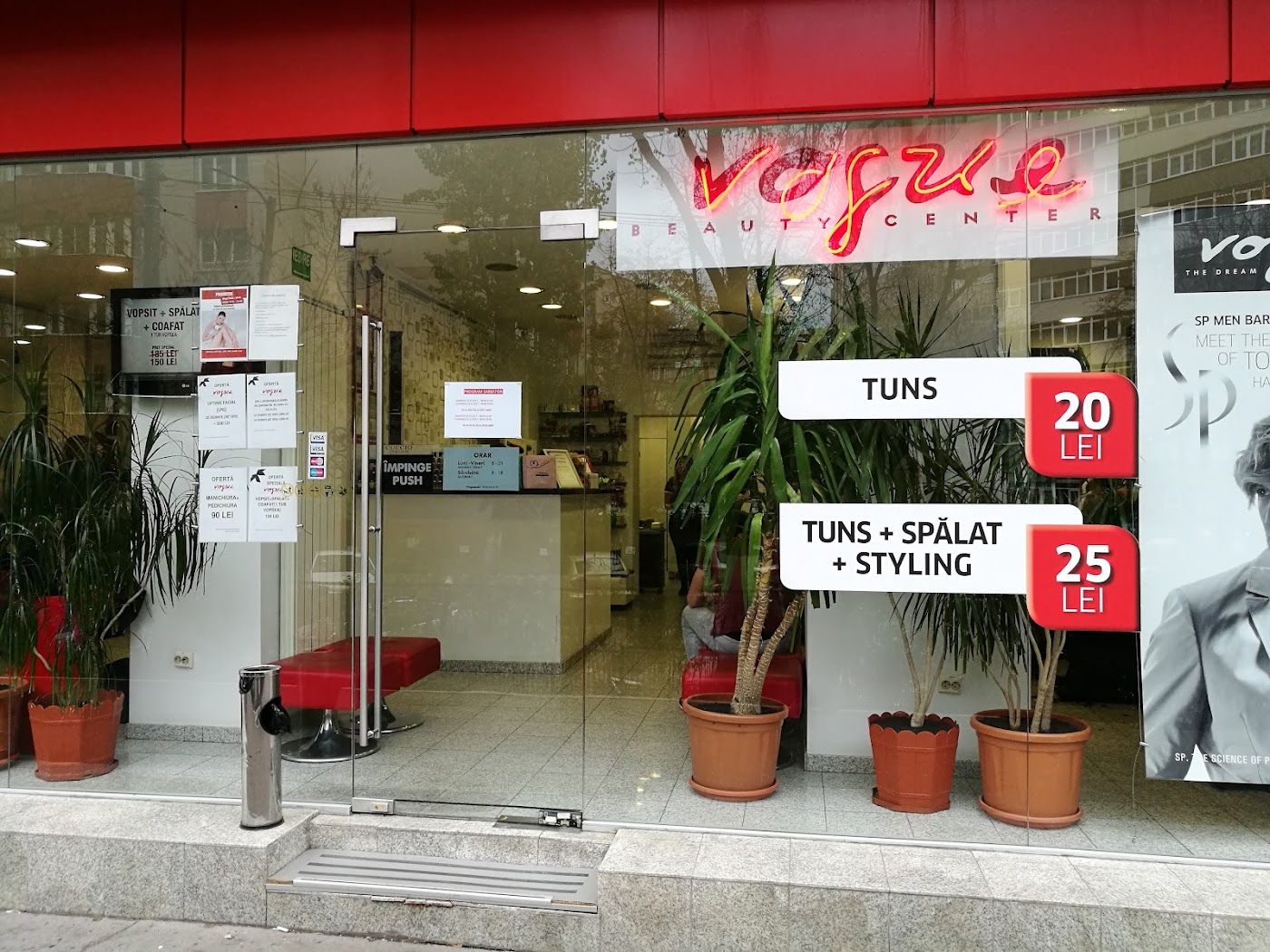 Vitrina salonului Dream ex Vogue, cu firma roșie Vogue și plante la intrare