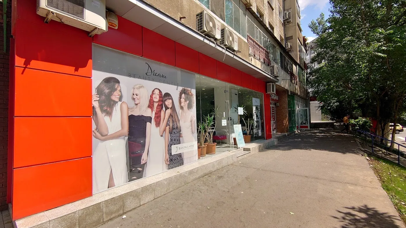 Fațada salonului pe stradă, cu panouri roșii și afișe cu modele